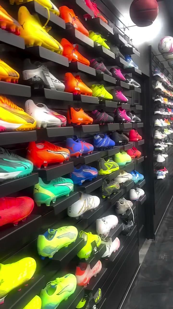 Wall of colorful Puma football boots at Xpress Sports