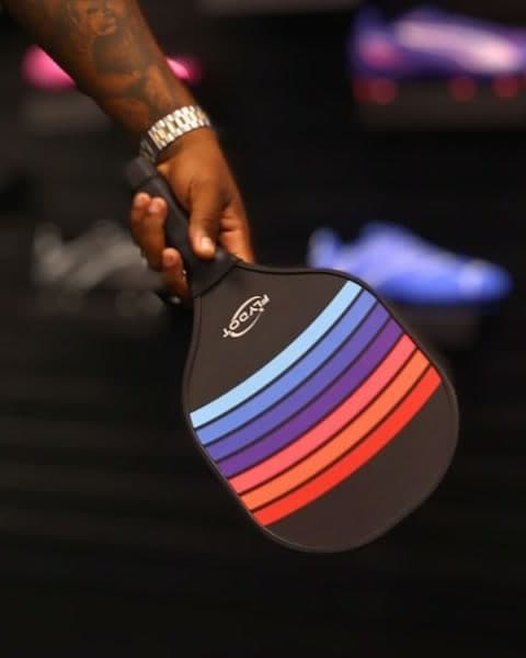 Rainbow-striped pickleball racket held in store at Xpress Sports