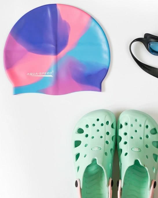 Swim cap, goggles and pool shoes laid out